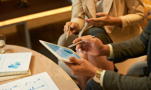 Hands of businessman showing diagram on tablet computer to his coworker